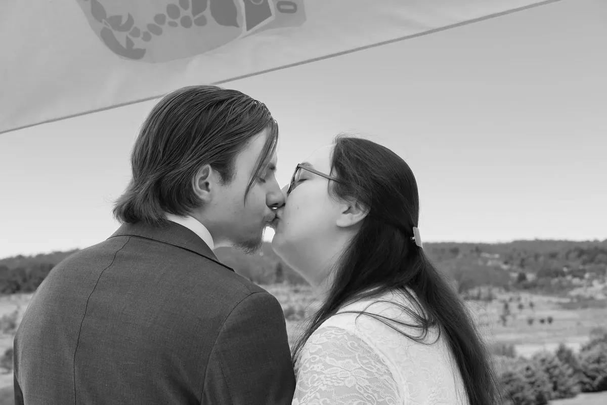Bride and groom sharing a kiss, black and white