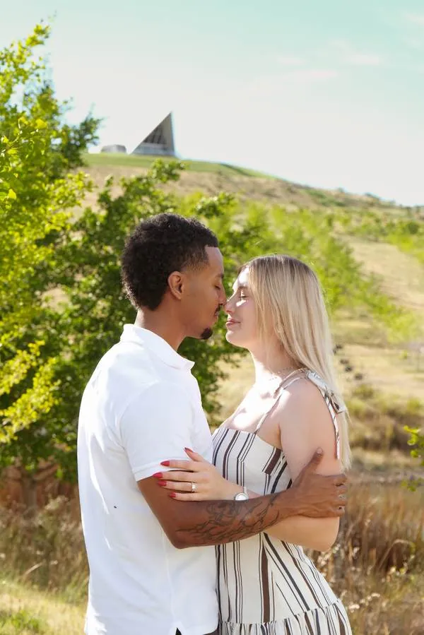 Couple hugging in a sunlit field