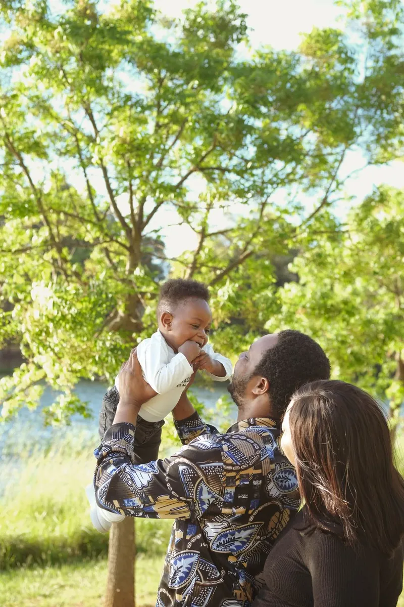 Father lifting his laughing toddler into the air