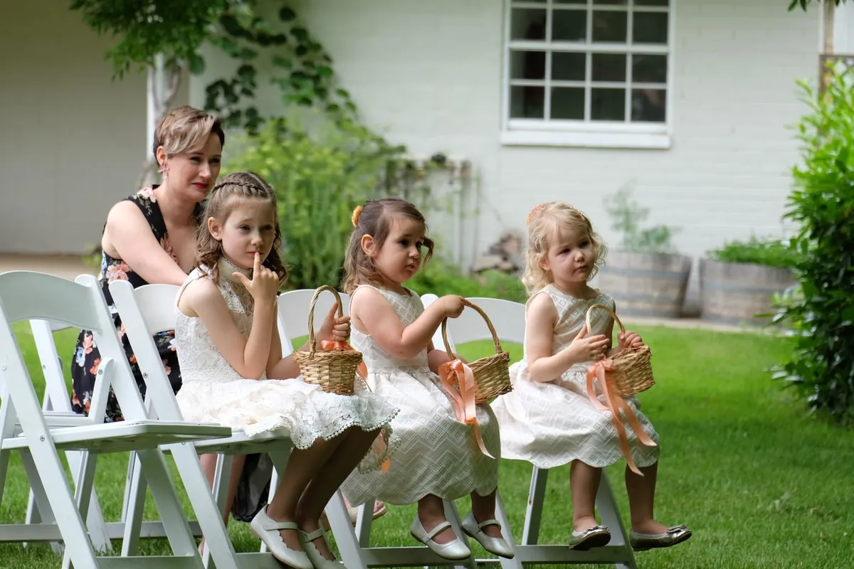Flower girls sitting with baskets before the ceremony