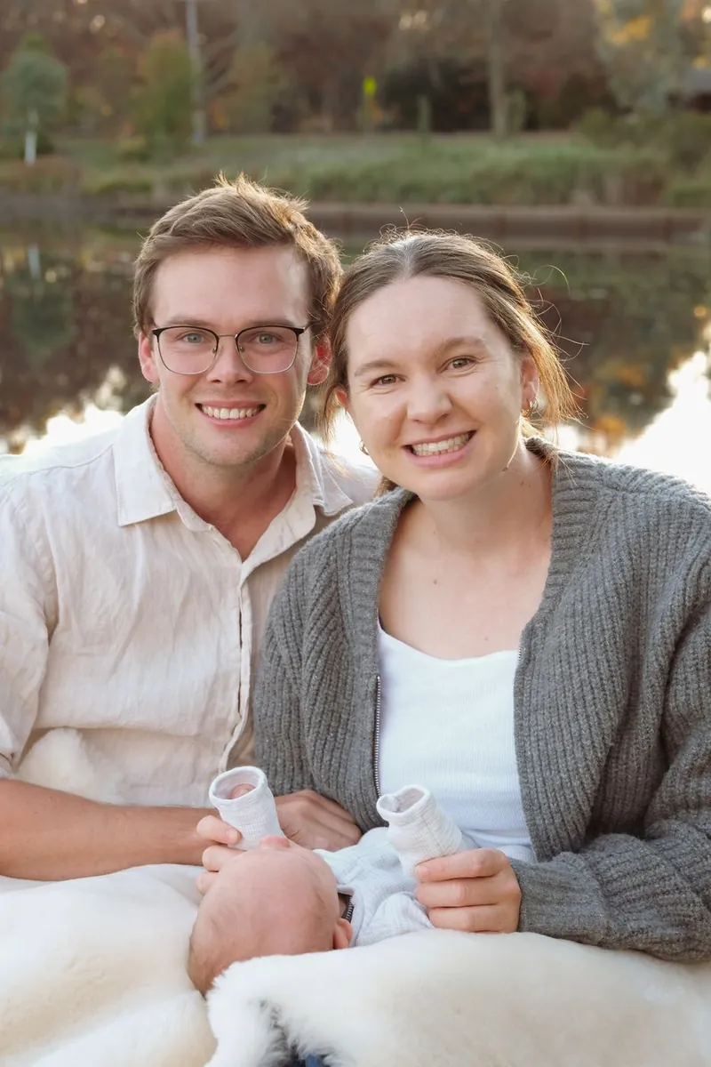Parents smiling, holding their newborn's little feet