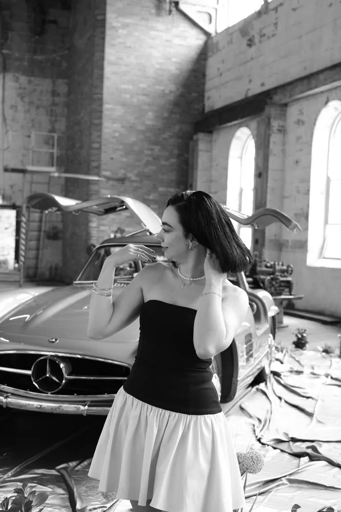 Portrait beside a vintage gullwing car, black and white
