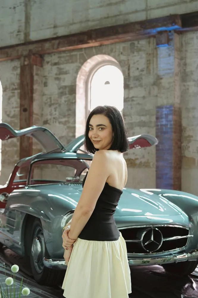 Portrait beside a vintage gullwing car, over-the-shoulder view