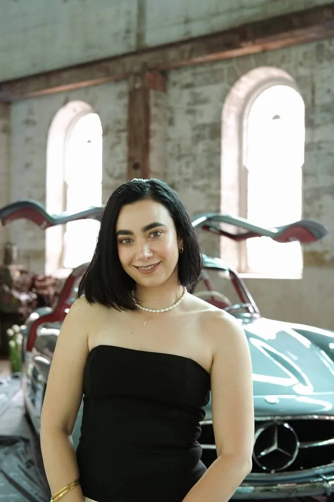 Portrait smiling in front of a vintage gullwing car