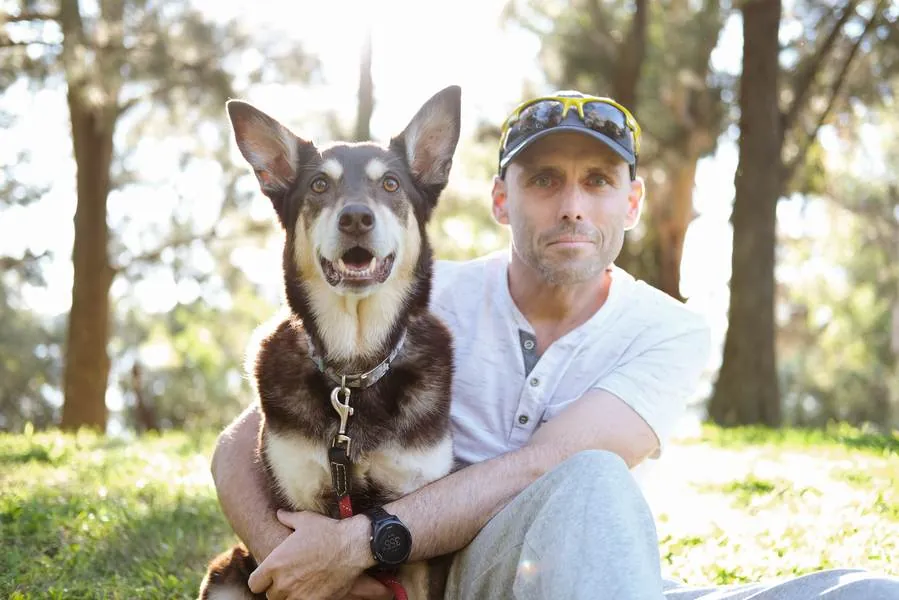Shiloh sitting on the grass, hugged by her owner